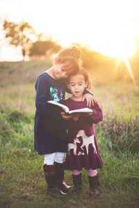Hijos leyendo cuentos infantiles en el bosque